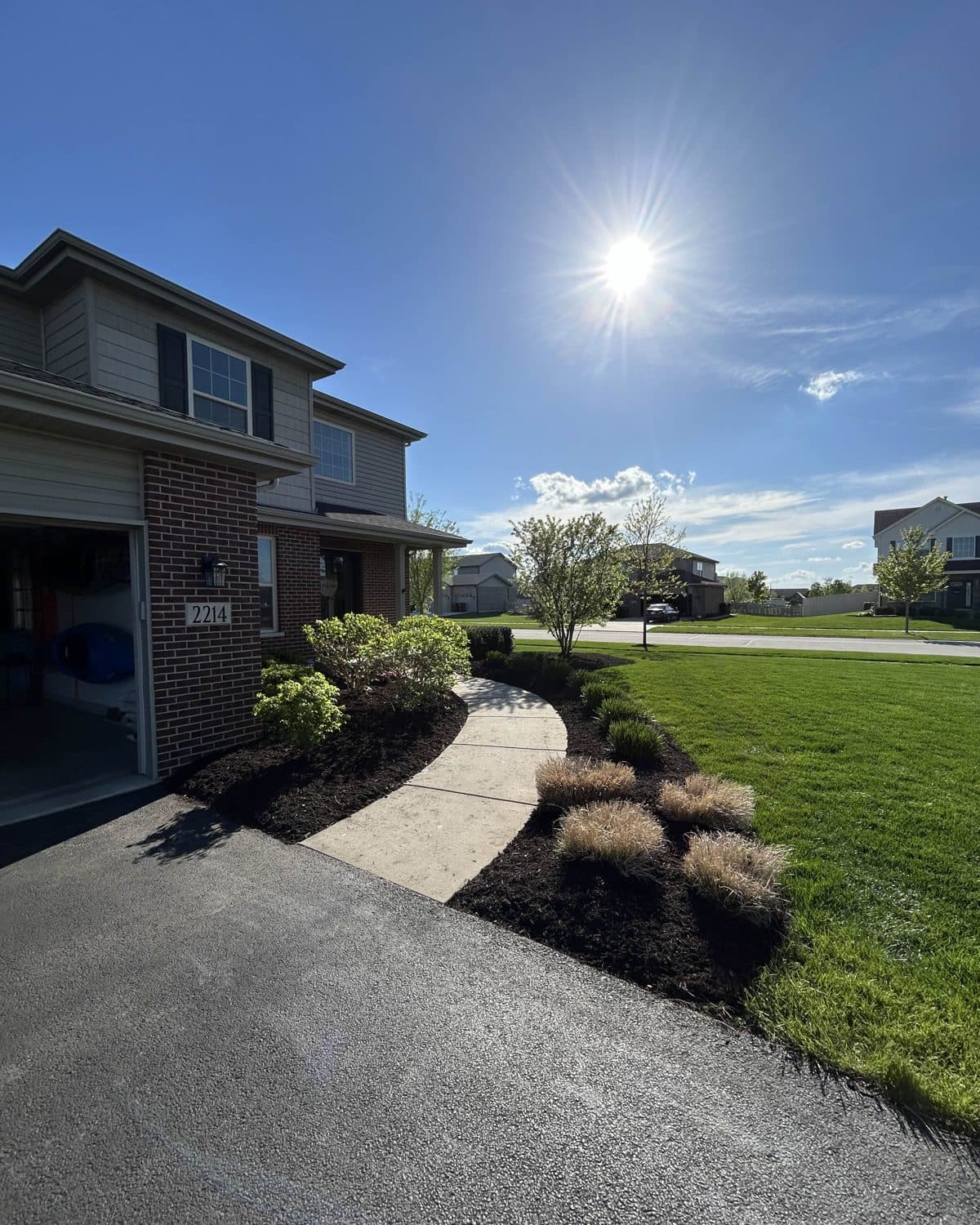 Fresh dark mulch installed along a driveway bed in the Manhattan, IL area